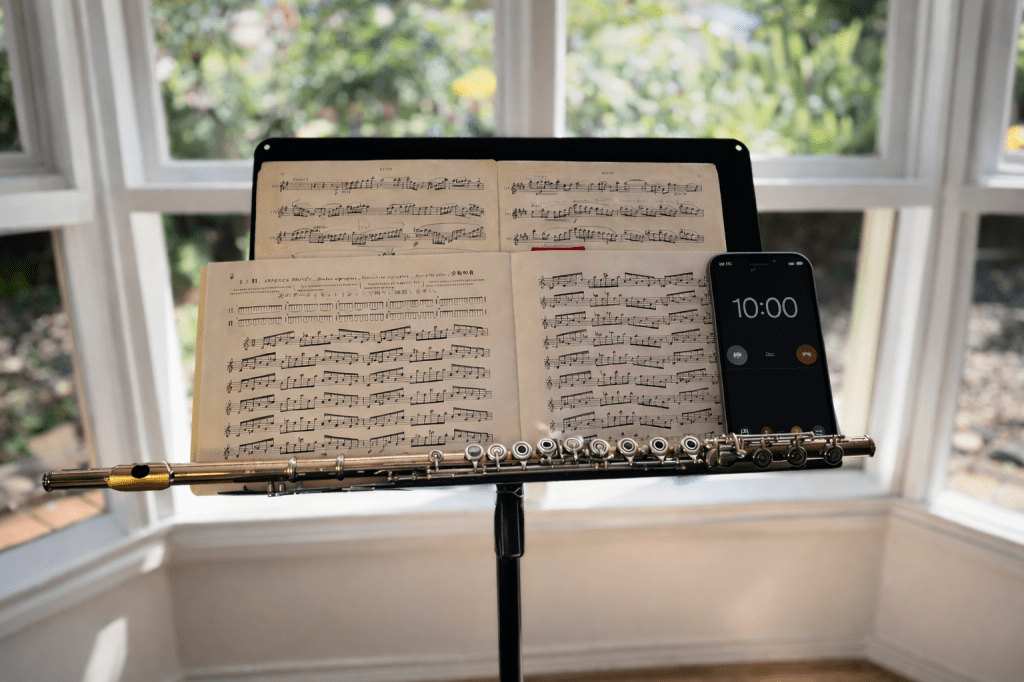 Phone timer set to ten minutes on a music stand with a flute nearby